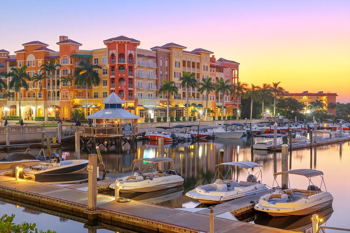 Photo of the Naples bay-front condominiums and boat docks at sunset.